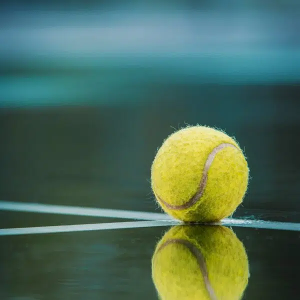 a tennis ball sitting on top of a tennis court